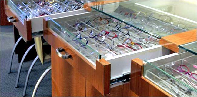 Cherry Burl Wood Eye Glass Display Counter - Top view. This modern style counter was designed for an upscale Eye Doctors office. It includes a 2 rows of pull draws with glass fronts and storage below.